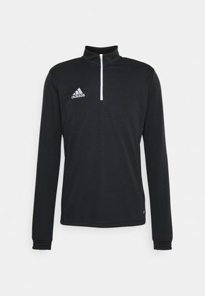 Sort langærmet atletisk top med halv-zip krave. Har hvid accent søm og et broderet logo på venstre bryst.
