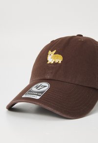 Brown baseball cap with a yellow embroidered corgi on the front and a tag displaying “47 CLEAN UP” and “ADJUSTABLE” attached.