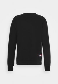 Černá mikina s dlouhým rukávem a kulatým výstřihem, s žebrovanými manžetami a lemem, pohled zezadu s malou nášivkou s logem Tommy Hilfiger nedaleko pravého spodního okraje.