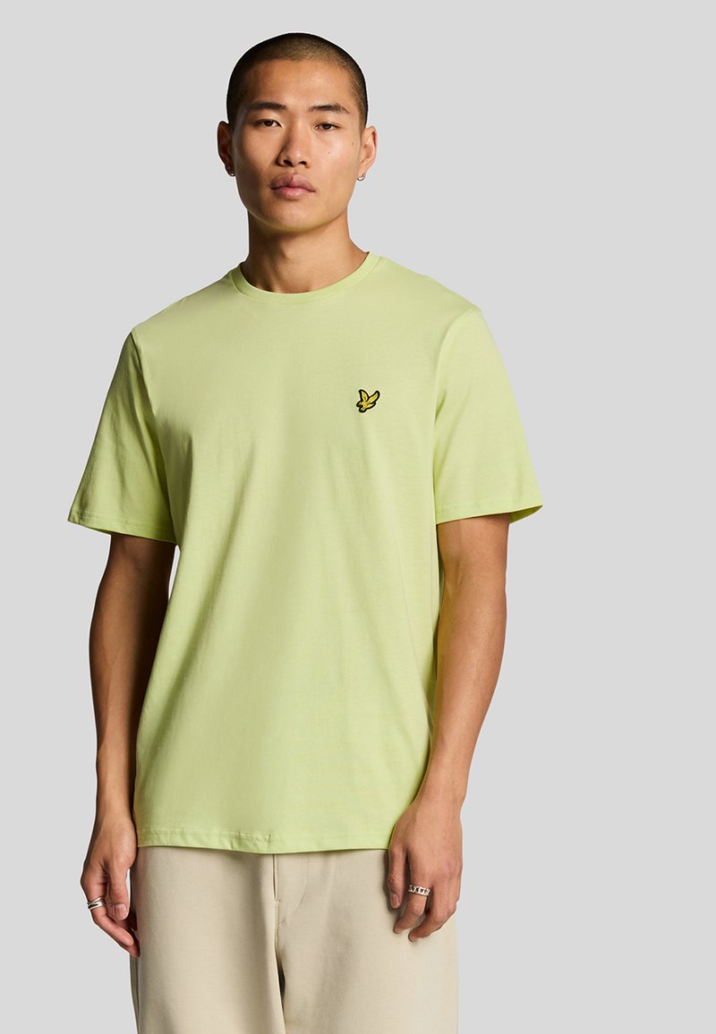Lys grøn bomulds T-shirt med en afslappet pasform, korte ærmer og et lille sort broderet logo på brystet.