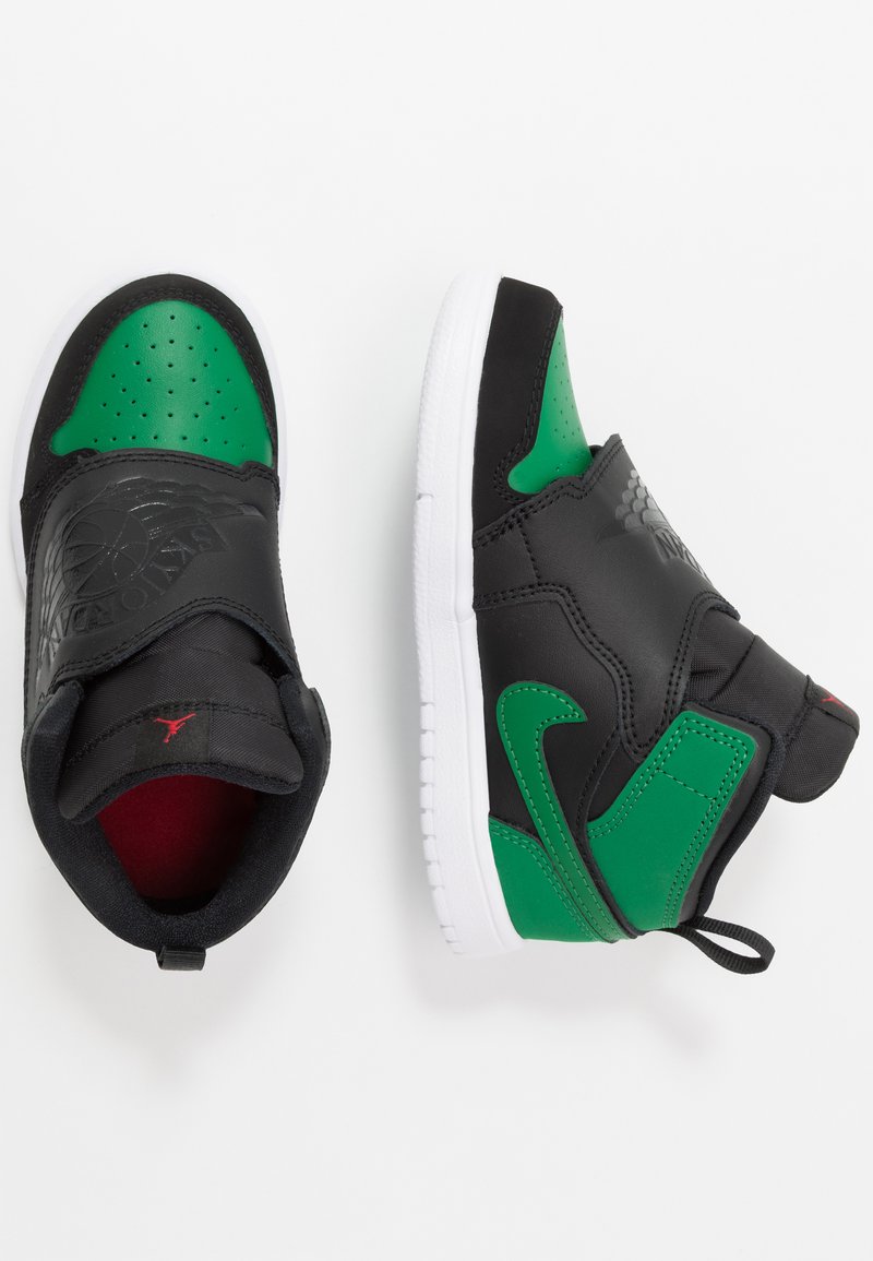 Sorte og grønne sneakers med en tekstureret læderoverdel, perforeret grøn tåboks og hvid gummisål. Har et logo på stropperne.