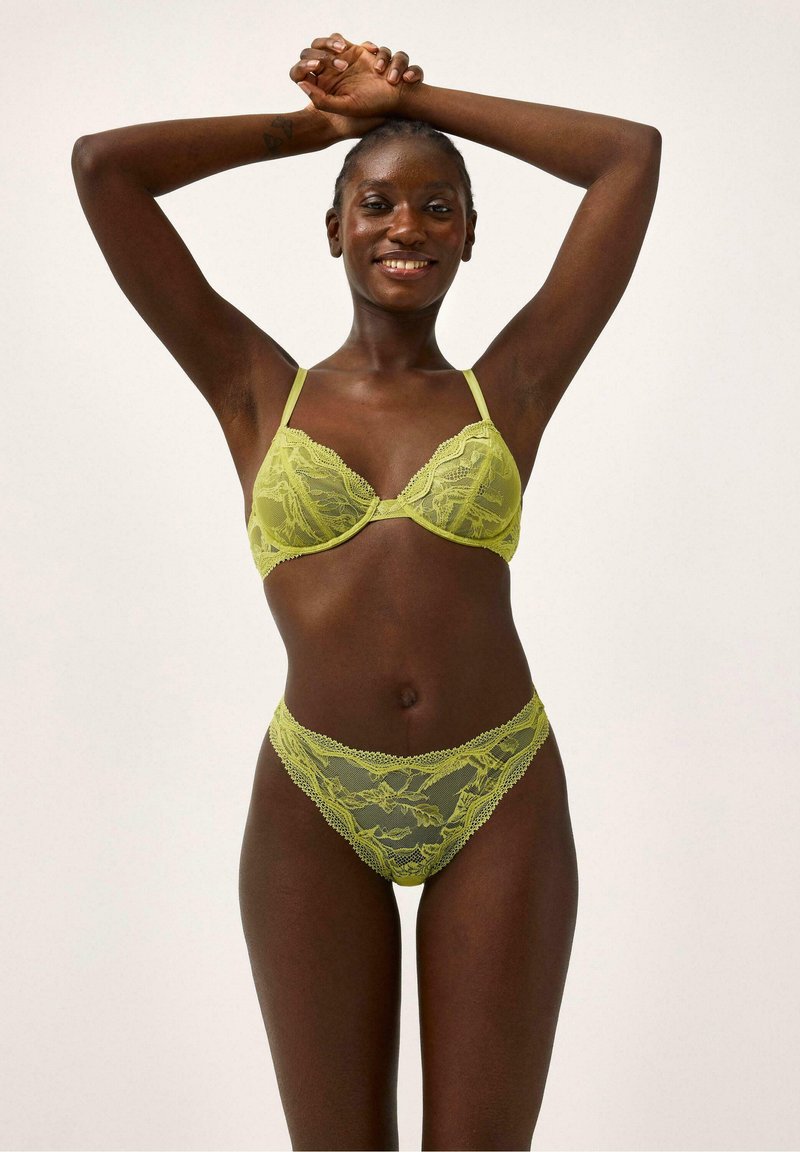Limoengroen kanten lingerie-set met een beha voorzien van beugels en verstelbare banden, gecombineerd met bijpassende kanten slips. Getextureerd bloemmotief.