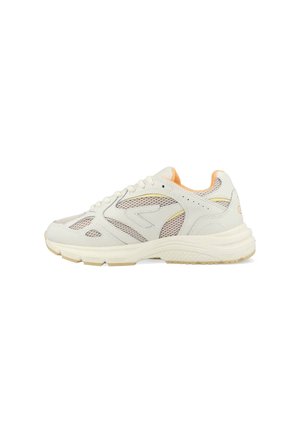 Baskets de sport blanches et beiges avec panneaux en maille, laçage à l'avant, col rembourré et semelle texturée, montrées en profil latéral.
