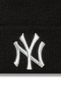 Fekete kötött sapka, amelyen elöl kiemelkedő fehér hímzett New York Yankees logo található, bordás textúrával a rugalmas illeszkedés érdekében.