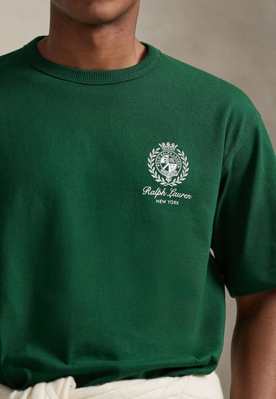 Πράσινο βαμβακερό T-shirt με στρογγυλή λαιμόκοψη, με λευκό κεντημένο λογότυπο και σχέδιο δάφνης στο στήθος. Κλασική εφαρμογή με κοντά μανίκια.