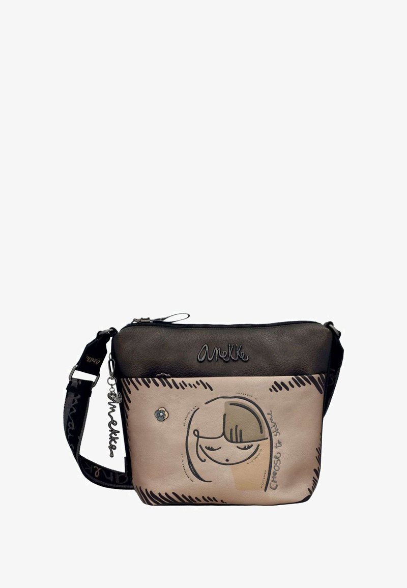 Beige und schwarze Leder-Crossbody-Tasche mit einer lächelnden Mädchenillustration, geprägtem Logo und verstellbarem Tragegurt. Kleine Blumenakzent.