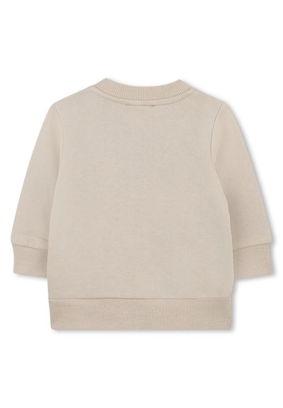 Sweatshirt beige clair avec un col rond côtelé, des manches longues, et un tissu texturé avec des détails au niveau des poignets et de l'ourlet.
