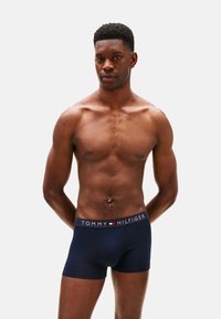 Bóxers de algodón azul marino con cintura elástica de logo en contraste. Textura suave y diseño ajustado que exhibe un estilo clásico.