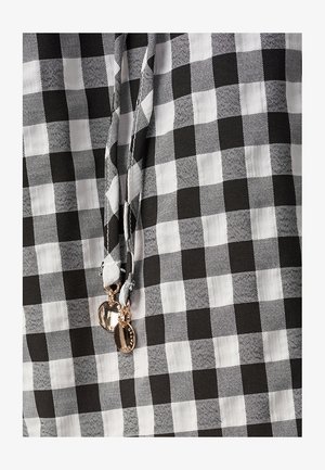 Schwarz-weißer karierten Stoff mit einem Zugband, das metallische silberne Akzente aufweist. Die Textur ist glatt und leicht.