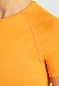 Korte mouw sporttop in feloranje, gemaakt van glad, rekbaar materiaal. Heeft een ronde halslijn en contrasterende stikdetails.