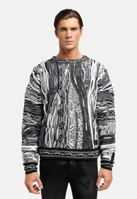 Sorte og hvide mønstrede sweater med et tekstureret design, der har detaljer med indviklet vævning samt en ribbet rund hals og manchetter.