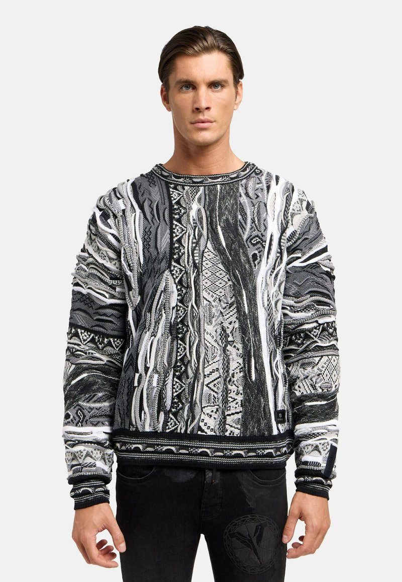 Sorte og hvide mønstrede sweater med et tekstureret design, der har detaljer med indviklet vævning samt en ribbet rund hals og manchetter.