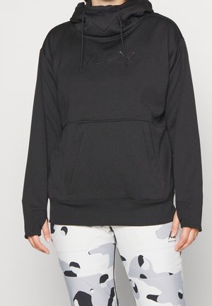 Sweat à capuche noir avec poche ventrale et cordon de serrage, porté avec un pantalon à motif camouflage blanc et gris.