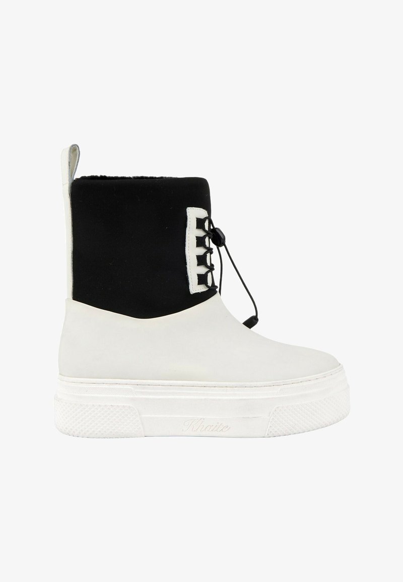 Botte blanche et noire mi-mollet avec une semelle blanche épaisse et un lacet noir réglable à l'avant avec fermeture à bascule.