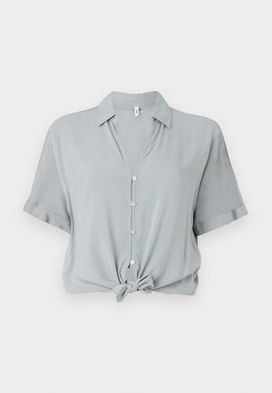 Heled hall, lühikeste varrukatega särk, millel on krae, ees nupud ja sõlmitud serv. Valmistatud siledast ja pehmest kangast.