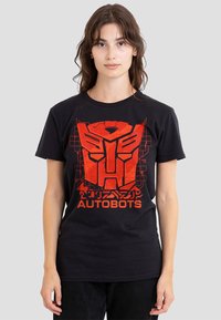 Schwarzes Baumwoll-T-Shirt mit einem großen roten "Autobots"-Grafikdesign mit kantigen Designelementen und Blockbuchstaben auf der Vorderseite.