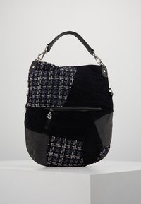 Torba patchworkowa z różnorodnych tkanin o fakturze w kolorach granatowym, czarnym i szarym. Posiada górny uchwyt, srebrne okucia oraz kieszeń na zamek.