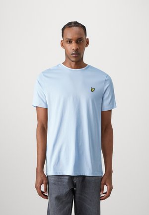 T-shirt in cotone azzurro chiaro con scollo rotondo, maniche corte e un piccolo dettaglio di una farfalla gialla ricamata sul lato sinistro del petto.