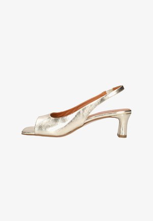 Metalen gouden open-teen slingback damesschoen met een lage gebogen hak en een beige voering, gezien van opzij tegen een witte achtergrond.