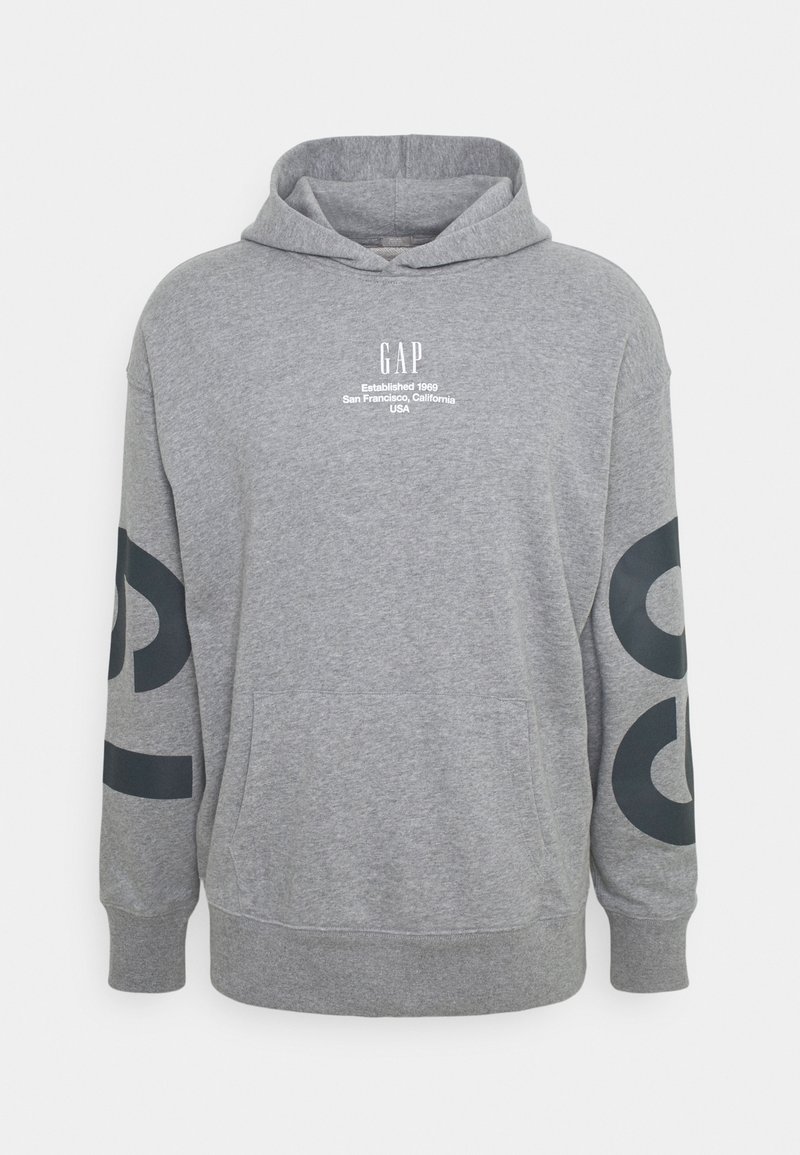 Sweat à capuche gris avec poche avant, capuche, logo GAP et texte sur la poitrine, ainsi que de grandes lettres noires sur les deux manches.