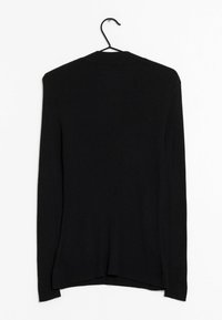 Schwarze gerippte Strickjacke mit langen Ärmeln und leicht abgerundetem Saum, auf einem Kleiderbügel vor einem schlichten Hintergrund präsentiert.