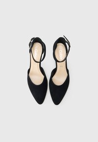 Schwarze Wildleder-Pumps mit spitz zulaufender Zehenpartie und Knöchelriemen, versehen mit einer Schnallendetail. Weiches Innenfutter sichtbar. Markenname "Gabor" auf der Sohle.