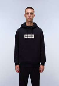 Black pullover hoodie in soft fabric features a front pocket and drawstring hood. White logo prominently displayed on the chest area.