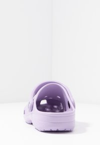 Saboti purple cu un finisaj neted și lucios. Include o curea din spate, orificii de ventilare și o talpă texturată pentru confort.