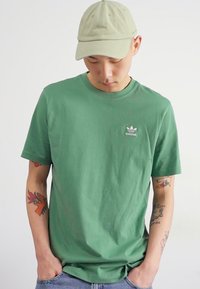 adidas Originals TREFOIL ESSENTIALS - Triko s potiskem - preloved green