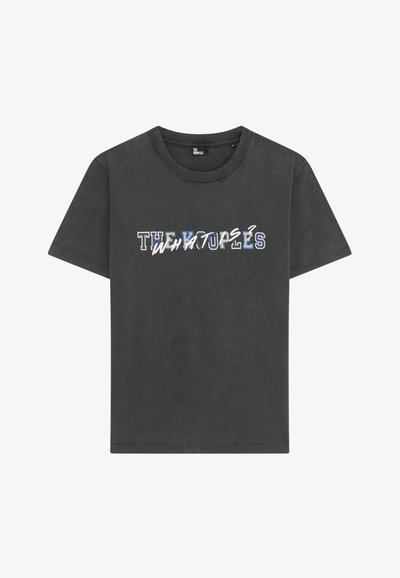 Tamsiai pilka medvilninė marškinėliai su apvalia iškirpte ir trumpomis rankovėmis. Priekyje yra užrašas įvairiomis šriftais ir spalvomis: "THE WHATUPS".