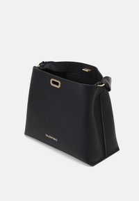 Black leather handbag with a structured shape, gold hardware accent, and embossed logo positioned at the bottom front. Adjustable strap included.