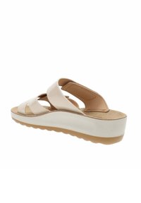Sandali platform beige con tomaia in pelle liscia, caratterizzati da cinturini incrociati e una soletta in sughero testurizzata. Suola in gomma spessa per una buona aderenza.