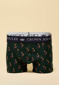 Green boxer shorts featuring a pattern of foxes in blue coats and red pants, with a navy elastic waistband displaying "CROWN JOULES" text.