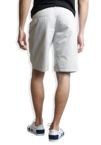 Shorts en coton gris clair à coupe droite, avec poches latérales et une poche arrière, assortis à des baskets blanches et marine.