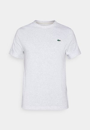 T-shirt en coton gris clair avec des manches courtes, encolure ras-du-cou, et logo brodé vert sur la poitrine gauche. Texture douce, design décontracté.