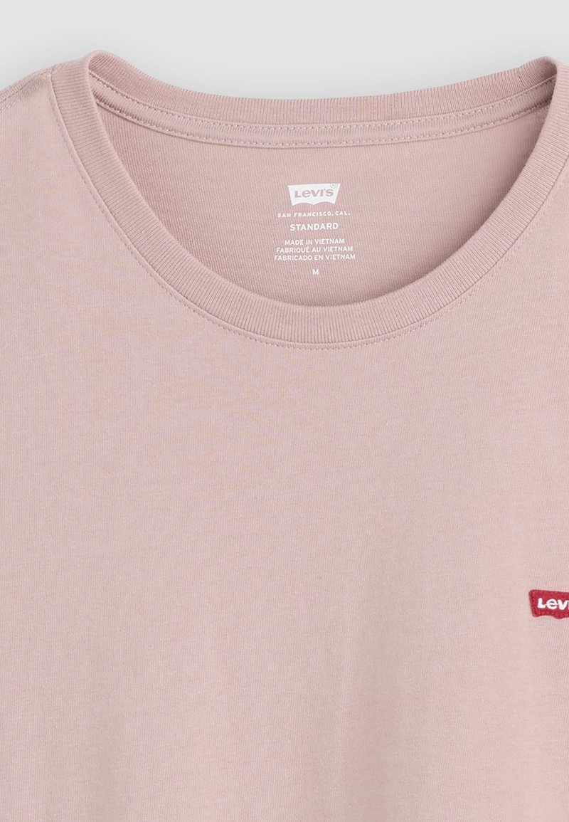 T-shirt Levi's rose clair col rond, taille moyenne, fabriqué au Vietnam avec étiquette de marque visible sur la poitrine et étiquette intérieure imprimée.