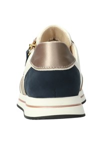 Basket avec cuir crème et accents en daim bleu marine, détail de fermeture éclair en métal doré, semelle en caoutchouc plate et panneau de talon texturé.