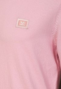 Light pink sweater made of soft knit fabric, featuring a small rectangular brand label with the text “V 1969 ITALIA” in the center.