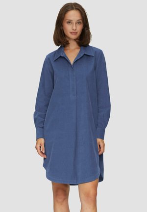 Blauwe corduroy jurk met een knoop-kraag, lange mouwen en een losse pasvorm. Heeft een subtiele ribbelstructuur en is van gemiddelde dijlengte.