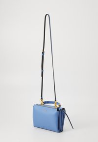 Niebieska skórzana torebka o strukturalnym designie, z zamkiem błyskawicznym na górze, złotymi akcentami i regulowanym czarnym paskiem. Gładka faktura i kompaktowy kształt.