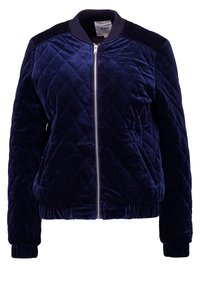 Giacca bomber trapuntata di velluto blu navy. Caratterizzata da una cerniera frontale, polsini a coste e dettagli sulle spalle. Finitura testurizzata con motivo a rombi.