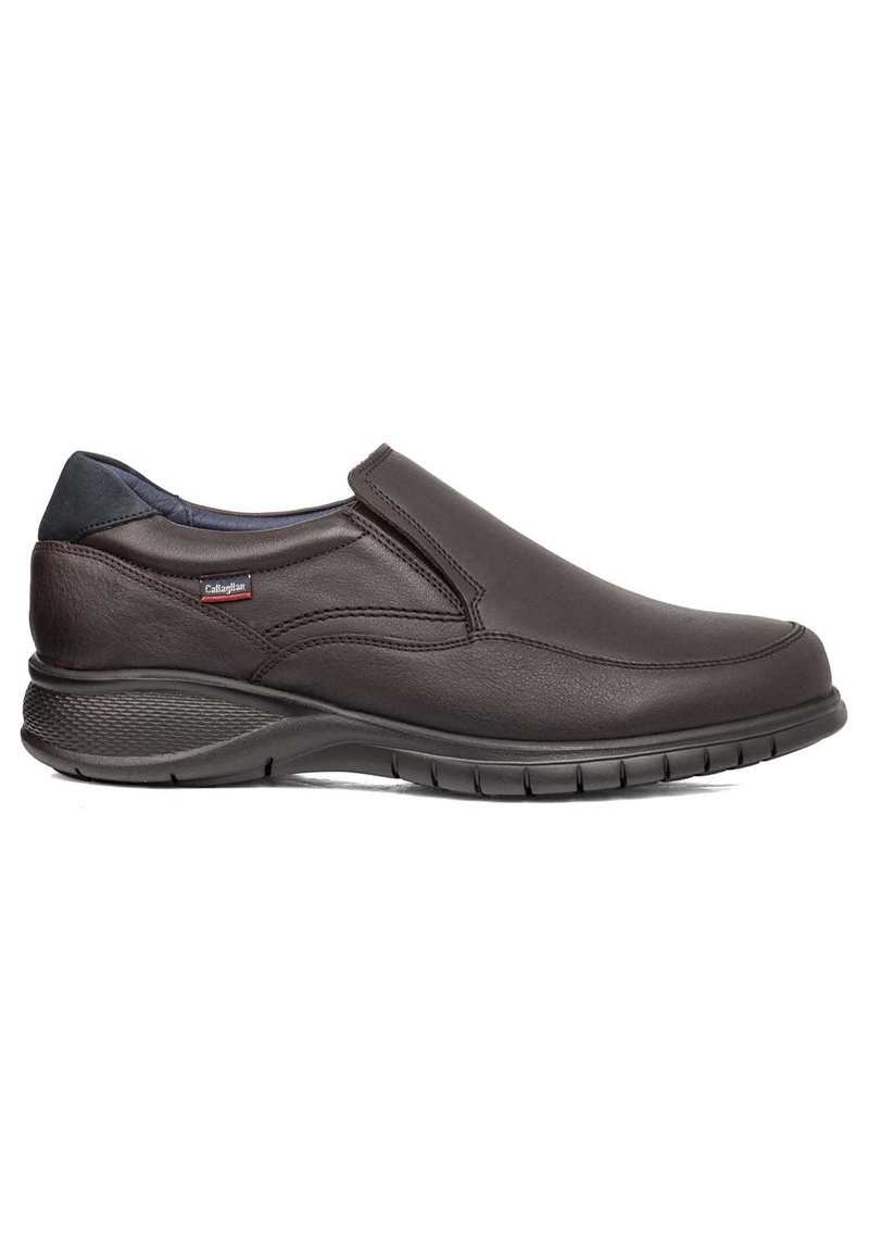 Zapato marrón de cuero sin cordones con un diseño elegante, punta redondeada, suela texturizada y gomas elásticas para un fácil uso. Presenta un sutil logo de la marca.