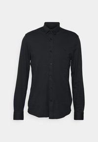 Camicia nera a maniche lunghe con bottoni, realizzata in tessuto morbido, caratterizzata da un colletto a punta, sette bottoni e un piccolo logo sul petto.