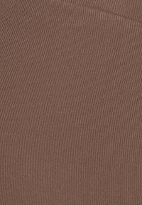 Hnědá žebrovaná tkanina s vertikální texturou a mírným elastickým tahem. Barva je teplý, tlumený odstín s rovnoměrným povrchem.