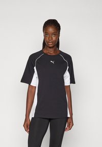 Korte mouwen shirt in zwart en wit, met een zwarte body, witte zijpanelen, ronde halslijn en een klein wit logo op de borst.