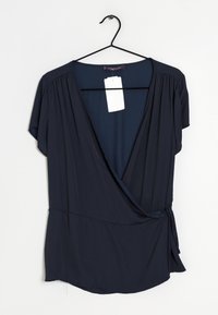 Blusa avvolgente blu navy a maniche corte, con una profonda scollatura a V, dettagli arricciati sulle spalle e un nastro di legatura laterale.