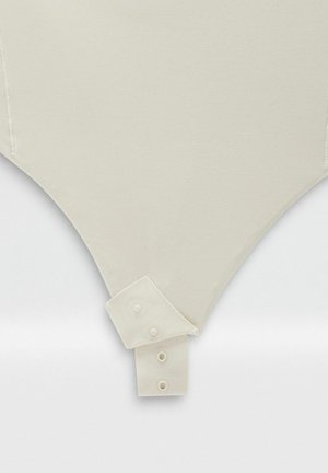 Body color crema con una texture liscia, caratterizzato da un dettaglio colletto con bottoni e un taglio triangolare aderente nella parte inferiore.