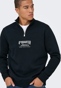 Zwarte sweatshirt met een ritskraag en een witte "4TH QUARTER Athletics" logo. Heeft ribgebreide manchetten en een ontspannen pasvorm.