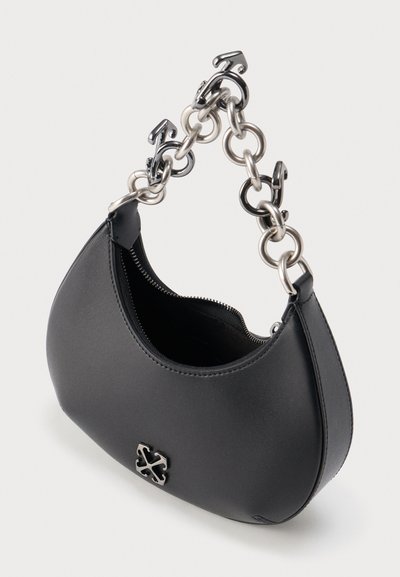 Sac à main en cuir noir avec anse en chaîne argentée composée de maillons en forme de flèches et logo métallique à l'avant, fermeture éclair partiellement ouverte sur le dessus.