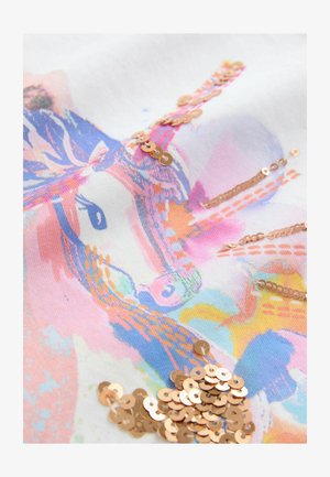 Valkoinen kangas, jossa on värikäs abstrakti kuvio, jossa on vaaleanpunaisia, sinisiä ja oransseja sävyjä. Kullansävyisiä paljetteja on ripoteltu pinnalle.